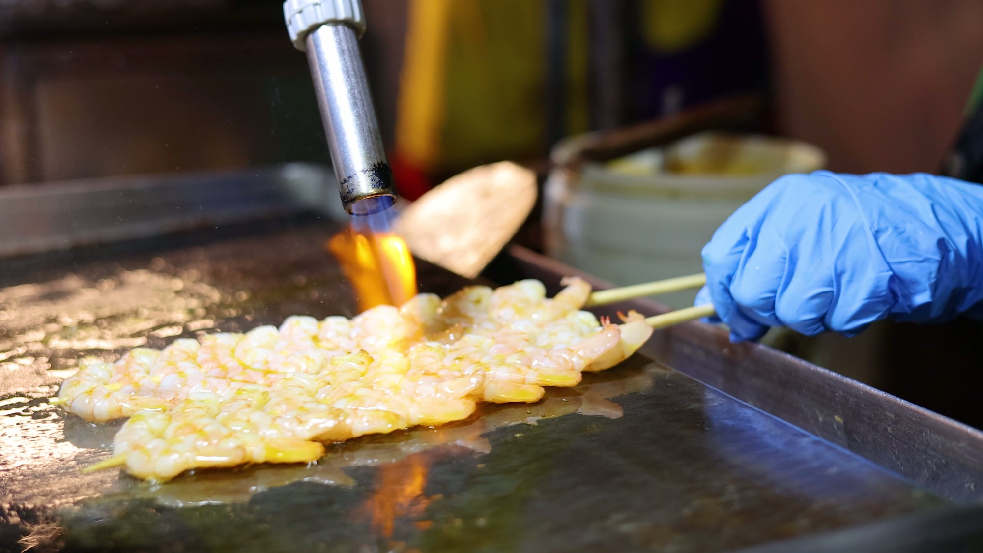 Street food vendor grilling skewers at a Bangkok night market