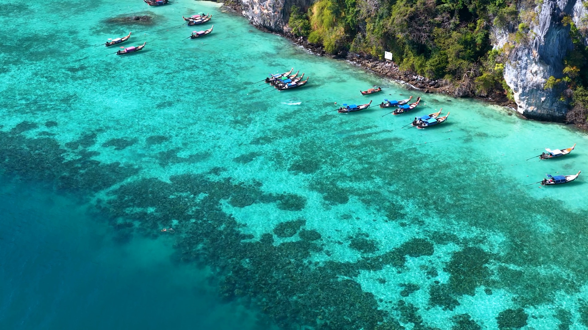 Aerial view of longtail boats in turquoise water at Phi Phi Island